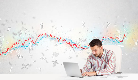 Business man sitting at table with stock market graph 3d letters