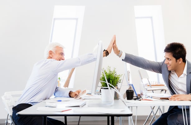 Businessmen in office cheering at their success