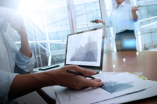 business documents on office table with smart phone and laptop computer and graph business with social network diagram and two colleagues discussing data in the background-2